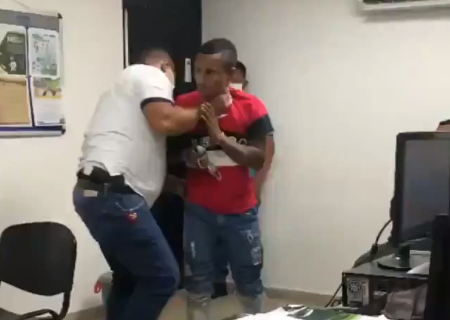 Policía colombiano levantó a un detenido agarrándolo por el cuello y lo lanzó con fuerza contra una pared